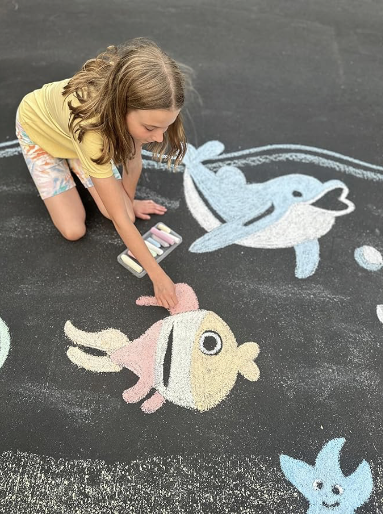 Kind malt mit bunter Straßenkreide auf Asphalt – kreative Beschäftigung für Kinder im Frühling